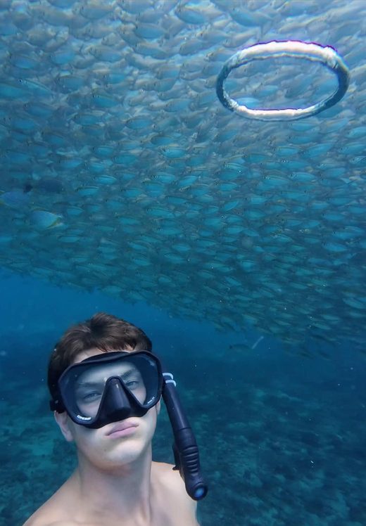 George with a bubble ring and a huge school of fish overhead